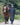 EQUIDRY women's long waterproof horse riding coat in black/turquoise modelled by rider walking with horse