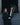 EQUIDRY women's long waterproof horse riding coat in black/turquoise modelled by rider on yard with horse