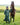EQUIDRY waterproof horse riding raincoat thin fleece pro ride reflective black forest green rider stood with horse full front view