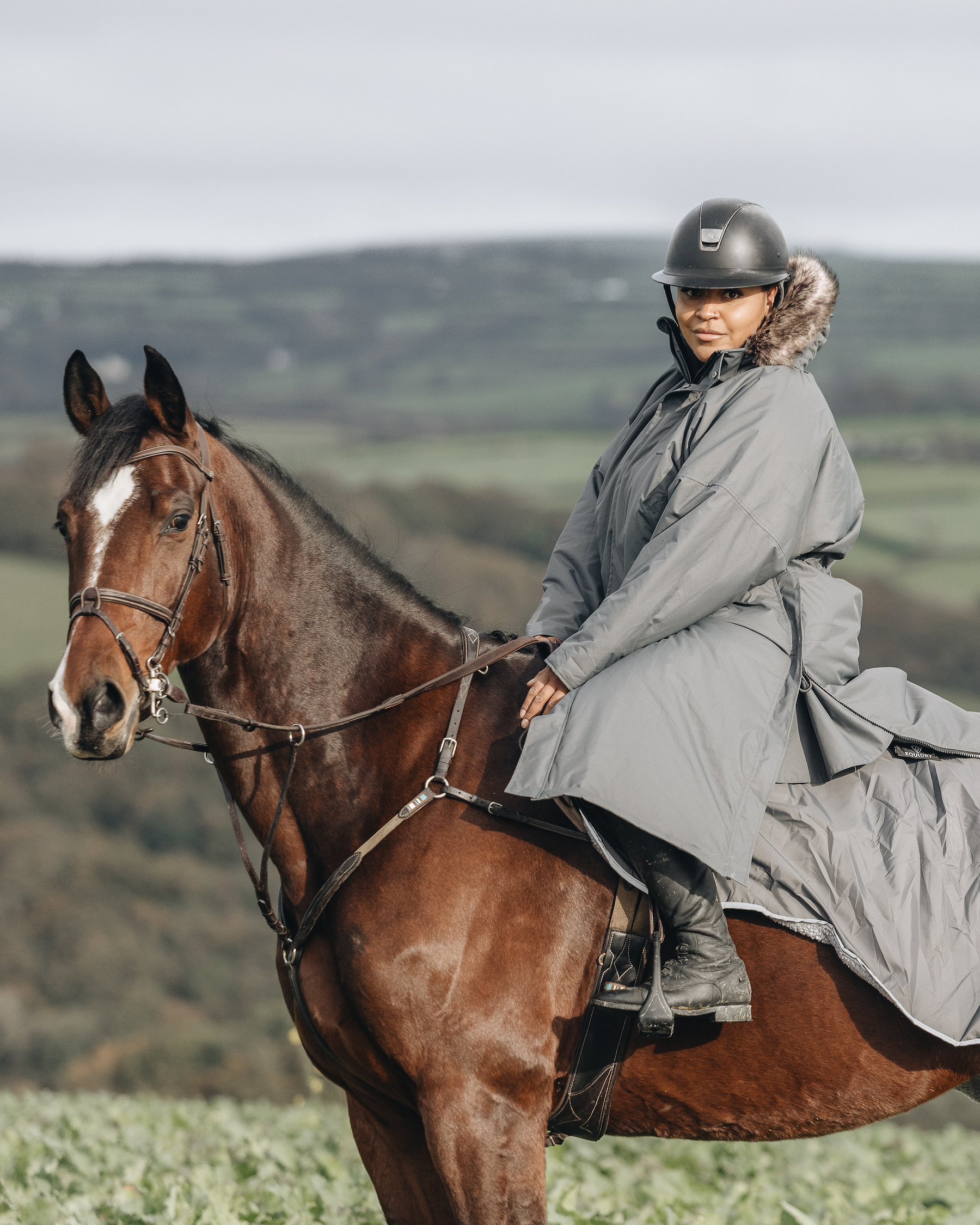 EQUIDRY Charcoal with fur h0od modelled by woman riding Horse cross country