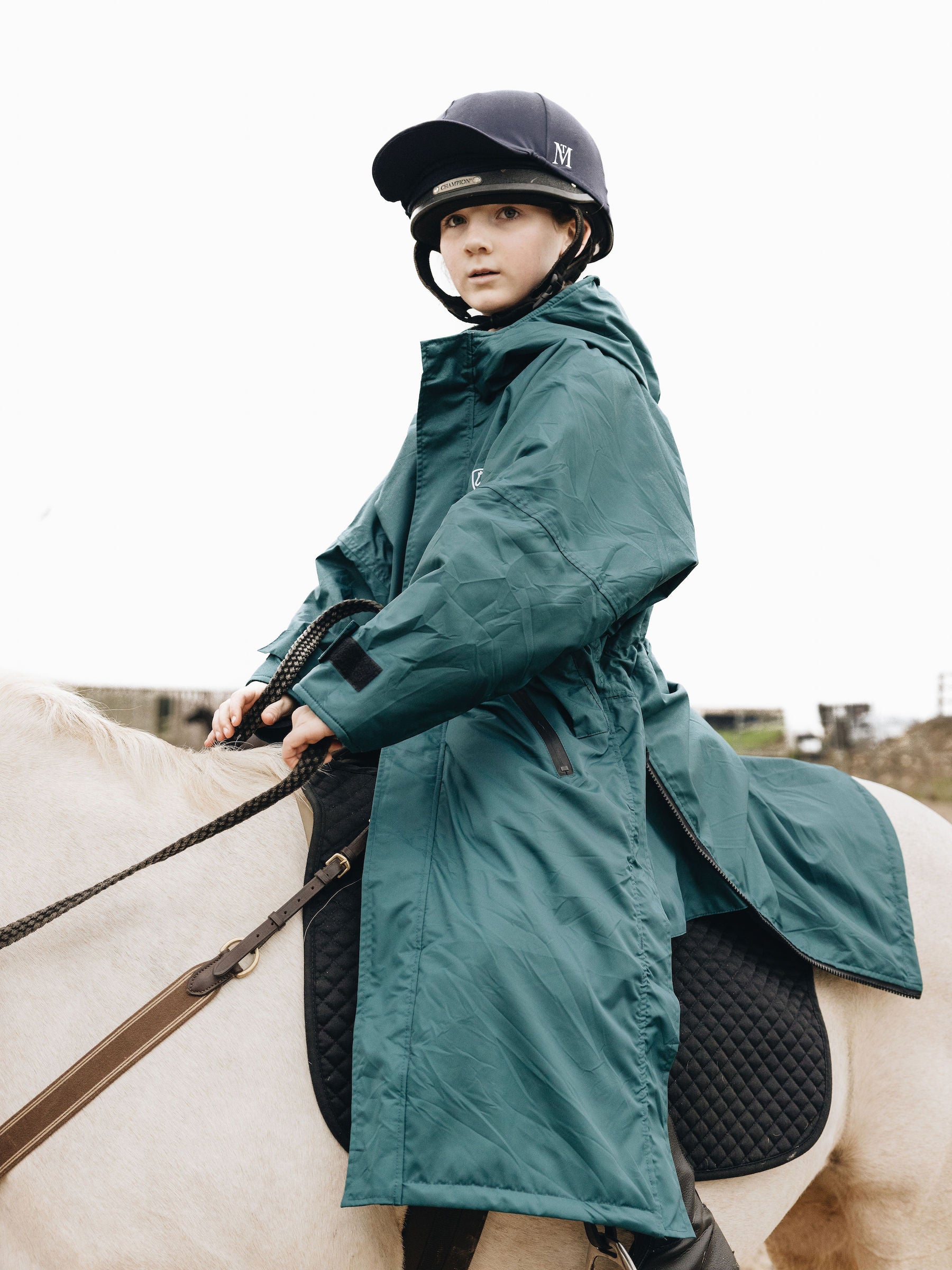 Teal EQUIDRY Equestrian oversized waterproof  Coat with side zips modelled by child riding pony  