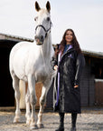 EQUIDRY women's long waterproof horse riding coat in Black/Lilac rider holding horse on yard