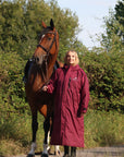 EQUIDRY women's long waterproof horse riding coat in plum/navy worn by rider with horse