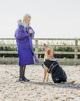 EQUIDRY Evolution Lux children's Warm Waterproof Winter Horse Riding Coat Thick Fleece Lining with Faux Fur Trim Hood being shown in purple by girl playing with dog in matching dog coat