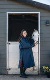 EQUIDRY Pro Ride Evolution Equestrian oversized waterproof Horse Riding Coat in Navy with Raspberry lining worn by young rider at stables with Pony