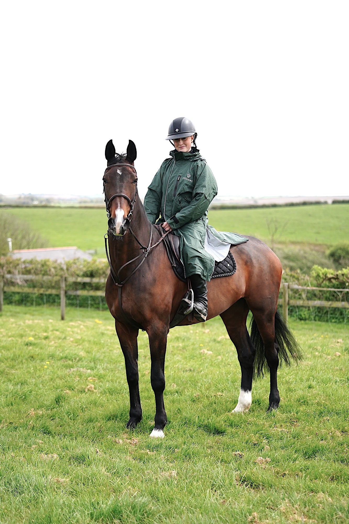 EQUIDRY waterproof horse riding raincoat thin fleece pro ride reflective black forest green rider on horse in field 