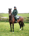 EQUIDRY waterproof horse riding raincoat thin fleece pro ride reflective black forest green rider on horse in field 