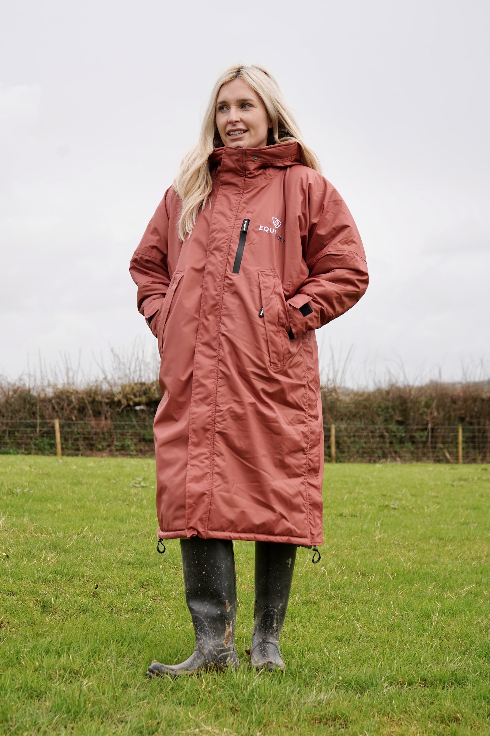 All Rounder Lux Chestnut EQUIDRY Equestrian oversized waterproof Horse Riding Coat with side zips modelled by a walker in the countryside