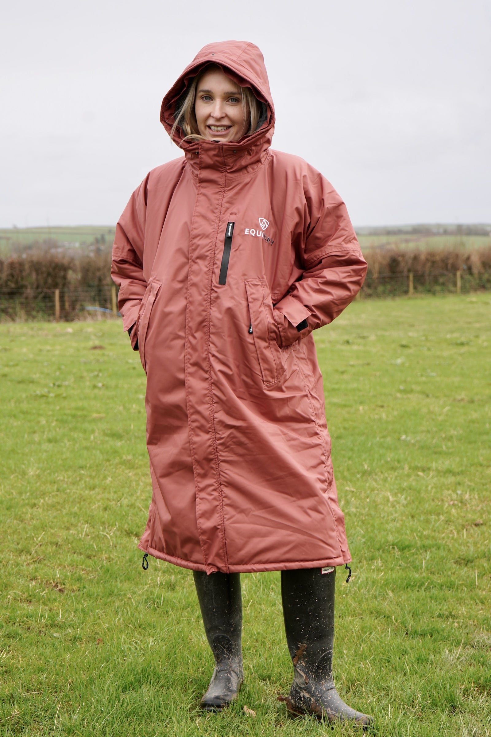 All Rounder Lux Chestnut EQUIDRY Equestrian oversized waterproof Horse Riding Coat with side zips modelled by a walker in the countryside