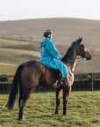 EQUIDRY women's thin fleece long waterproof horse riding coat in turquoise on horse side view