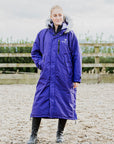 EQUIDRY Evolution Lux Women's Warm Waterproof Winter Horse Riding Coat Thick Fleece Lining with Faux Fur Trim Hood purple rider in arena full front view 