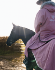 EQUIDRY Evolution Lux Women's Warm Waterproof Winter Horse Riding Coat Thick Fleece Lining with Faux Fur Trim Hood dusky pink on horse with matching exercise sheet