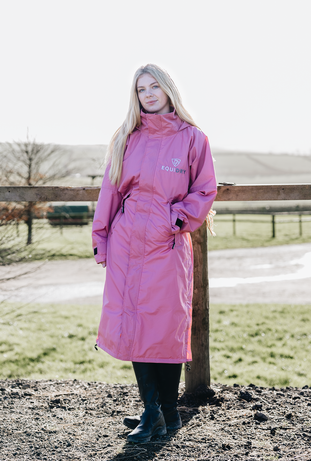EQUIDRY Pink long lightweight waterproof horse riding coat worn by female adult 