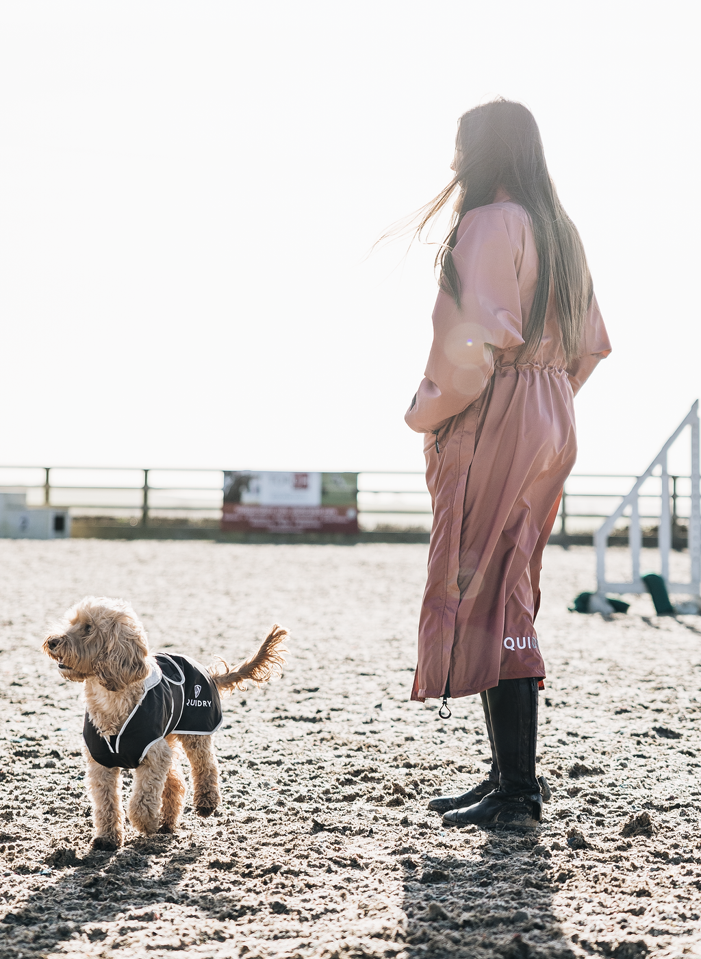 EQUIDRY chestnut Equimac long waterproof lightweight rain coat worn by dog walker in Equestrian setting 