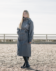 EQUIDRY Charcoal Equimac long waterproof lightweight riding coat modelled by female horse riding instructor 