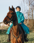 EQUIDRY women's thin fleece long waterproof horse riding coat in turquoise on horse