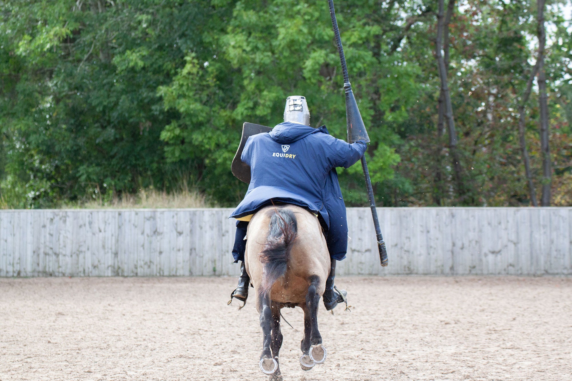 EQUIDRY men&#39;s long waterproof horse riding coat in navy/yellow worn by male stunt rider back of coat