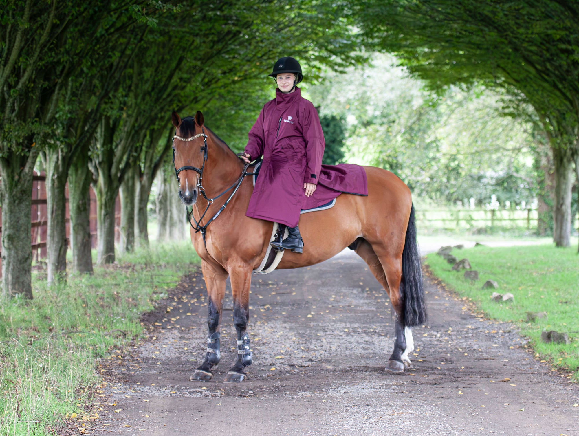 EQUIDRY women&#39;s thin fleece stowaway hood long waterproof horse riding coat in plum on horse