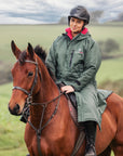 EQUIDRY women's long waterproof horse riding coat in black forest green/peacock pink shown by rider out hacking on horse