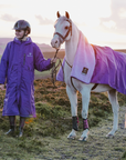 EQUIDRY women's long waterproof horse riding coat in deep purple/lilac with horse wearing matching exercise sheet