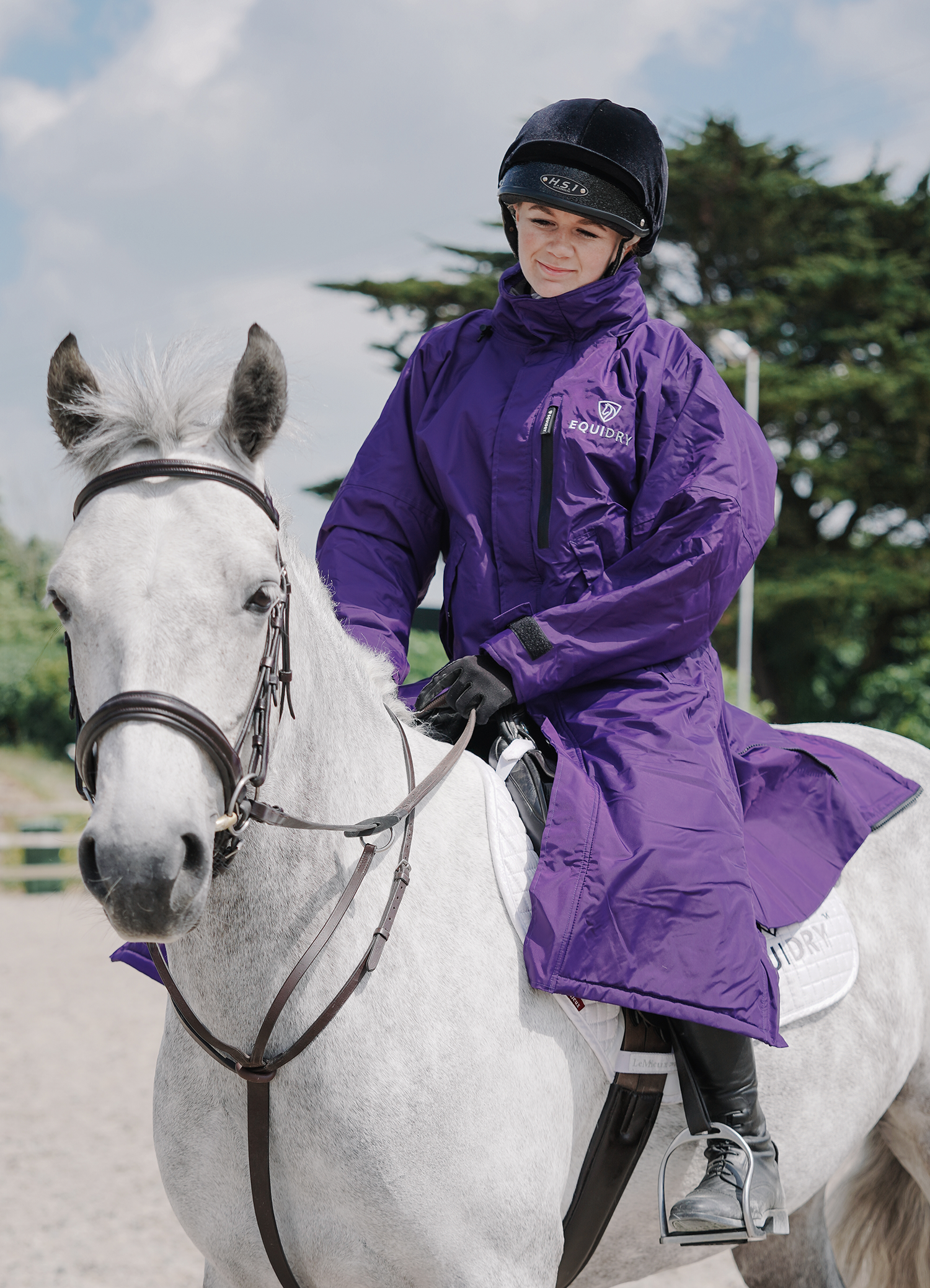 EQUIDRY women's thin fleece stowaway hood long waterproof horse riding coat in purple on horse